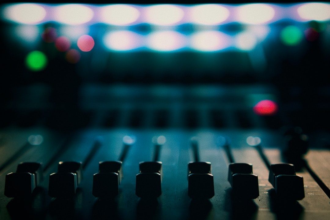 Console de mixage audio aux commandes éclairées sur fond flou